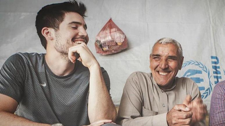 Mike Clarke '11 (right) speaking with an older person,